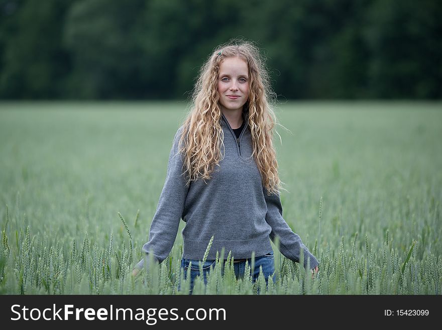 young woman standing in a green field