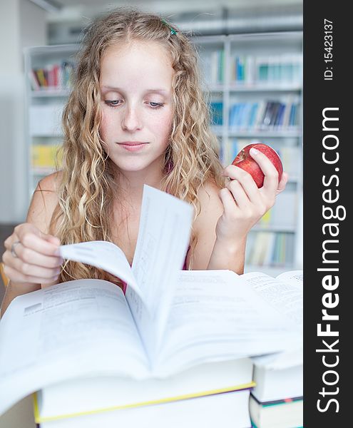 Pretty female college student in a library