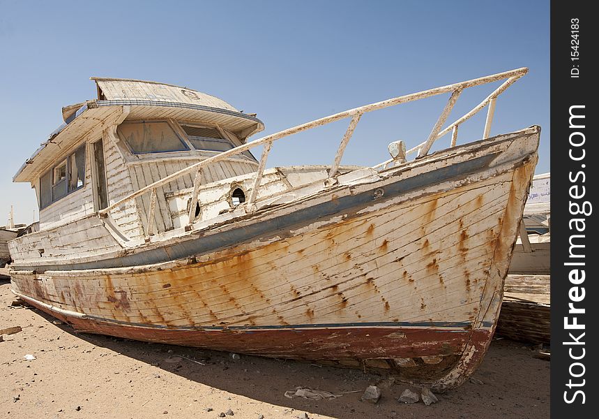 An abandoned derelict wooden boat in the desert. An abandoned derelict wooden boat in the desert