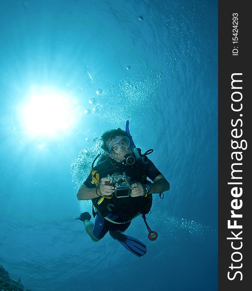 Scuba diver with camera and sun ball