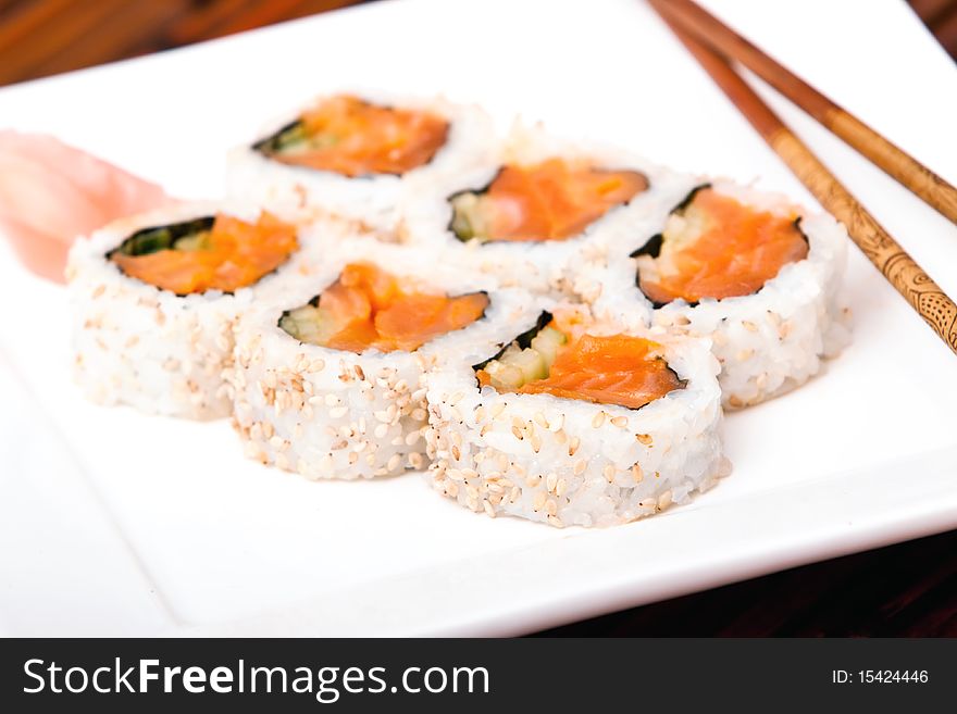 Salmon rolls with chopsticks on a plate