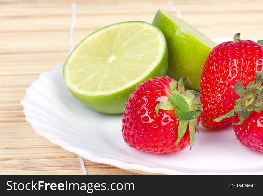 Strawberries And Limes On White Plate