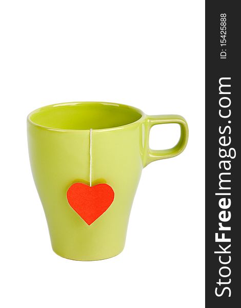Tea bag with red heart-shaped label in green cup isolated on white