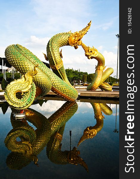 Couple of golden naga or dragon statue over water pool. Couple of golden naga or dragon statue over water pool