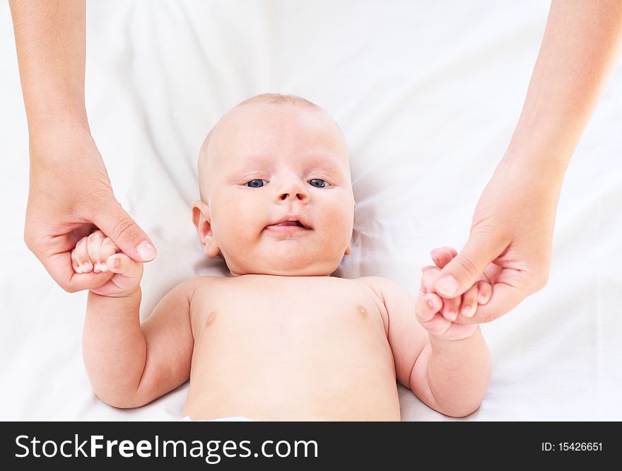 The parent holds for hands of the baby. Age - 3 months