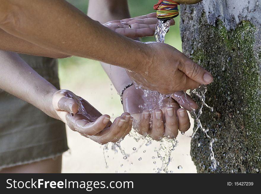 This image shows a person getting wet hands in a fountain