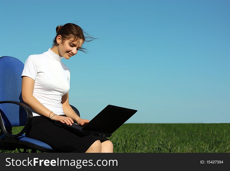 Young businesswoman with laptop in the field. Young businesswoman with laptop in the field