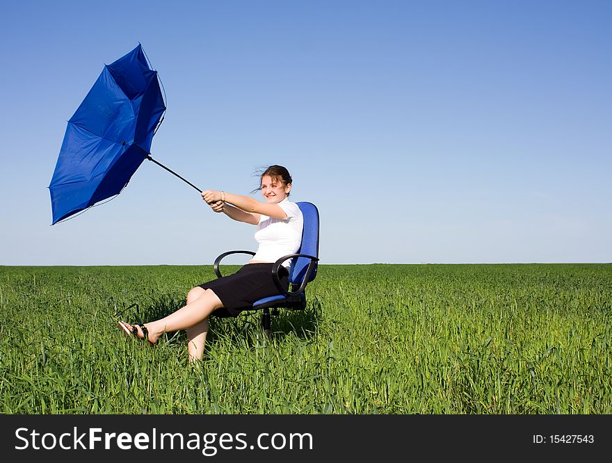 Business women with an umbrella on a grass land