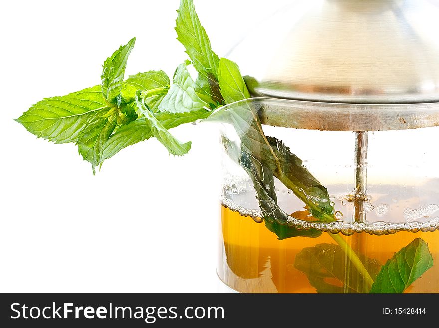 Mint tea in a teapot and a bundle of mint