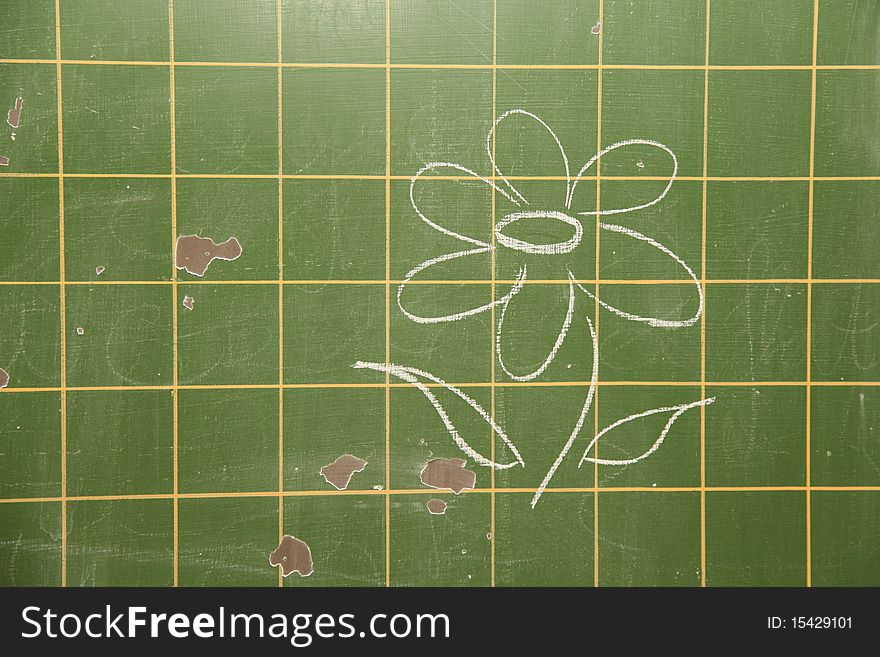 Old school board. A flower was drawn on it with chalk.