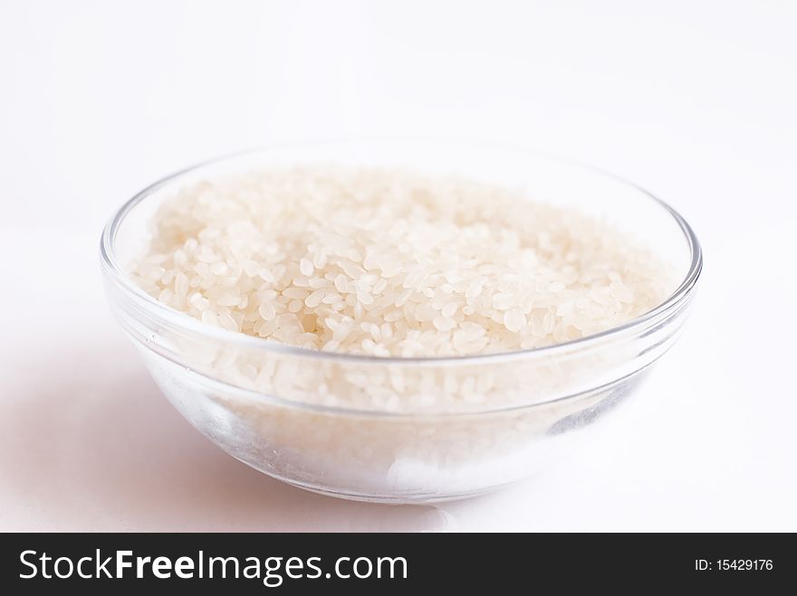 Cup with raw rice on isolated background