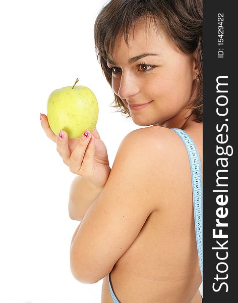 Young girl with measuring tape around slim beautiful waist and holding an apple