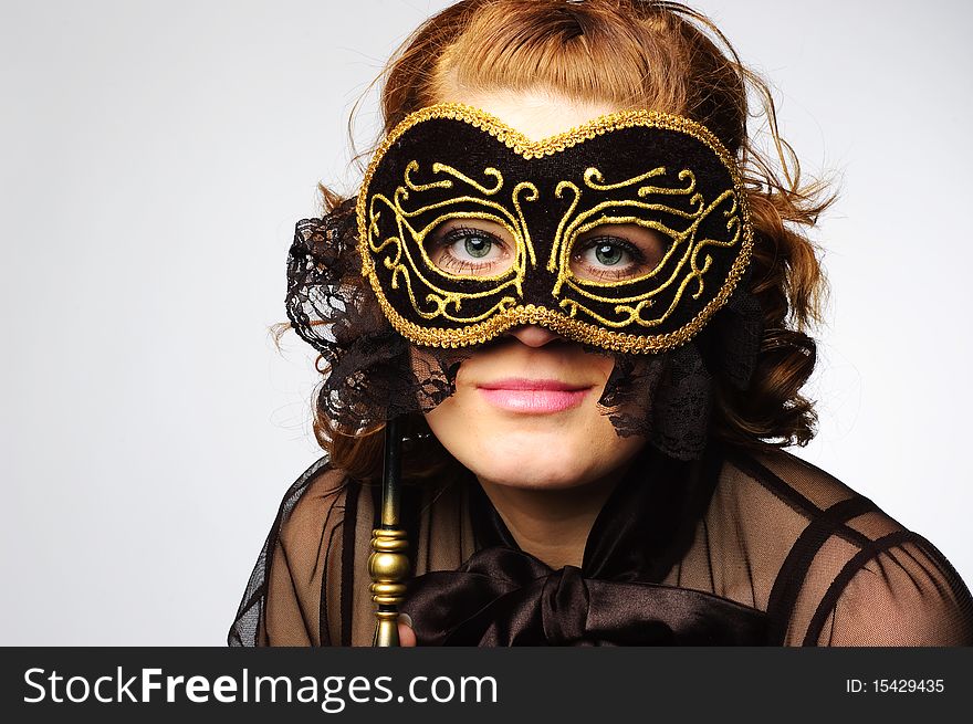 Beautiful woman hides her face behind the carnival mask. Isolated on the white background. Beautiful woman hides her face behind the carnival mask. Isolated on the white background.