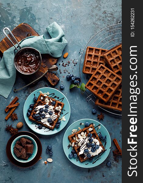 Chocolate Belgian Waffles With Ice Cream And Fresh Blueberry On Blue Background