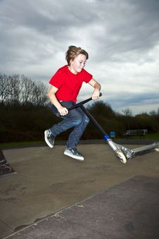 Boy Going Airborne With A Scooter Stock Images