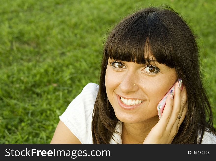 Young beautiful woman on the phone in the park. Young beautiful woman on the phone in the park.