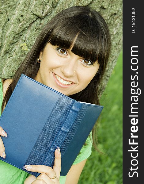 Young beautiful woman in a park with a notebook. Young beautiful woman in a park with a notebook.