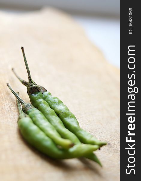 Green chilies on a wooden cooking desk