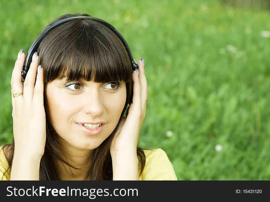 Smiling young woman listening to music at park