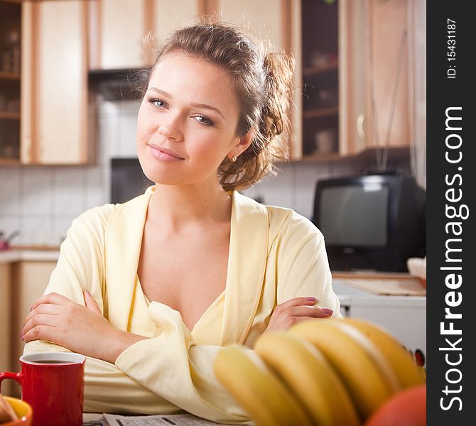 Pretty woman in the kitchen looking at camera having a breakfast