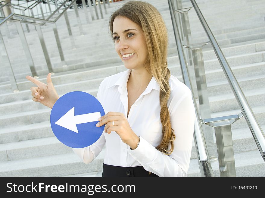 Close-up of a young woman gesturing. In the hands of a traffic sign