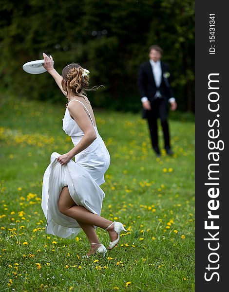 Young wedding couple - freshly wed groom and bride posing outdoors on a lovely spring day