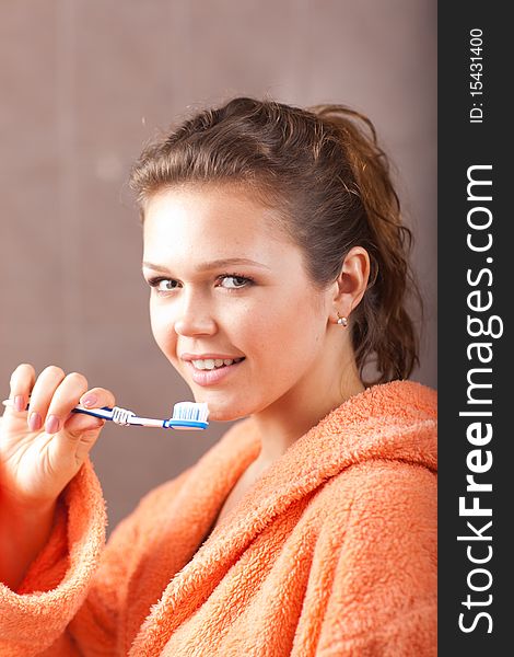 Pretty woman with healthy smile brushing teeth in the bath. Pretty woman with healthy smile brushing teeth in the bath