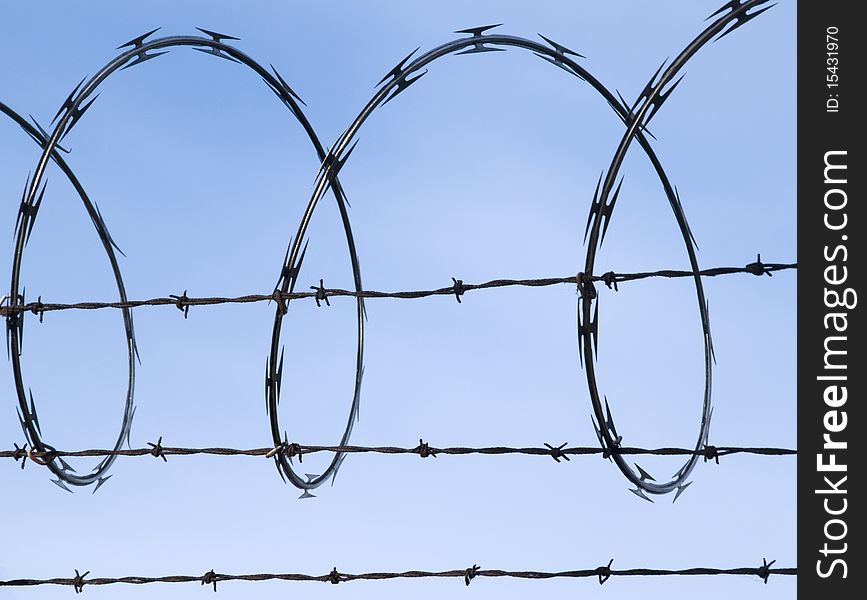 Barbed Wire Fence Against Blue Sky