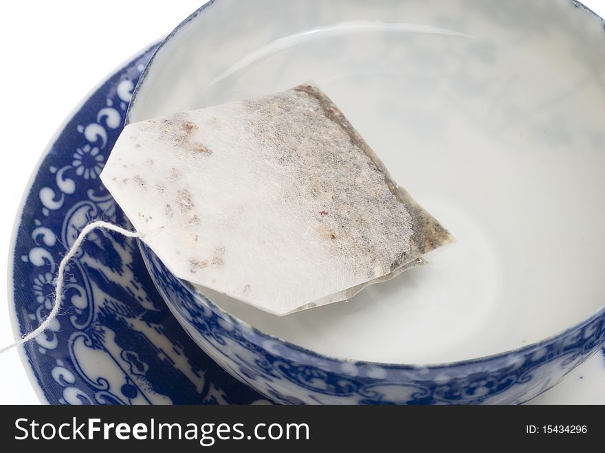 Tea bag in cup and hot water