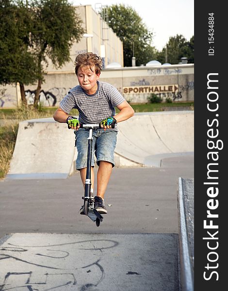 Boy riding scooter at a skate park
