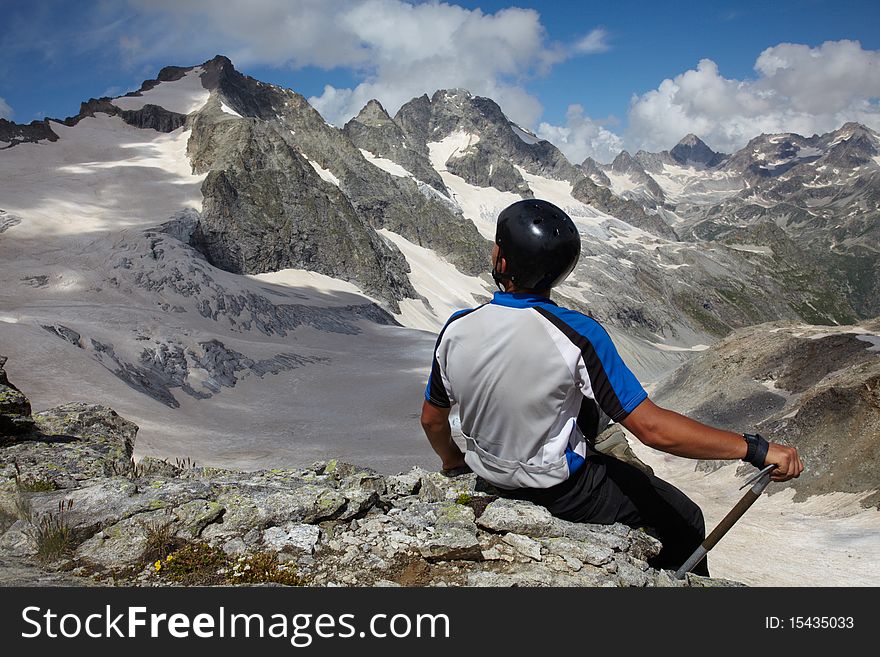 Man in helmet looking to a mountain peak. Man in helmet looking to a mountain peak