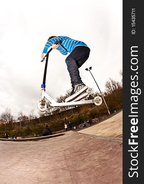 Boy riding a scooter gone airborne on a scooter park. Boy riding a scooter gone airborne on a scooter park