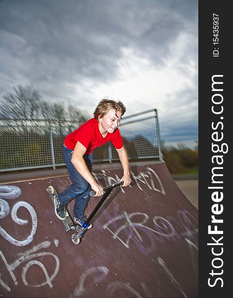 Boy riding a scooter going airborne at a scooter park. Boy riding a scooter going airborne at a scooter park