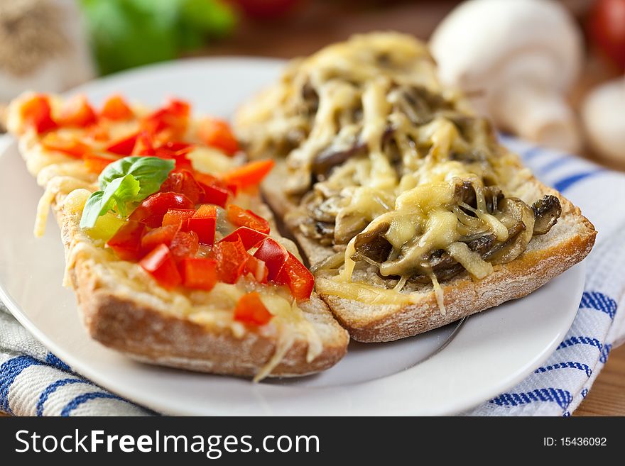 Close up of toasts with cheese,pepper and mushrooms in a rustic dish. Close up of toasts with cheese,pepper and mushrooms in a rustic dish