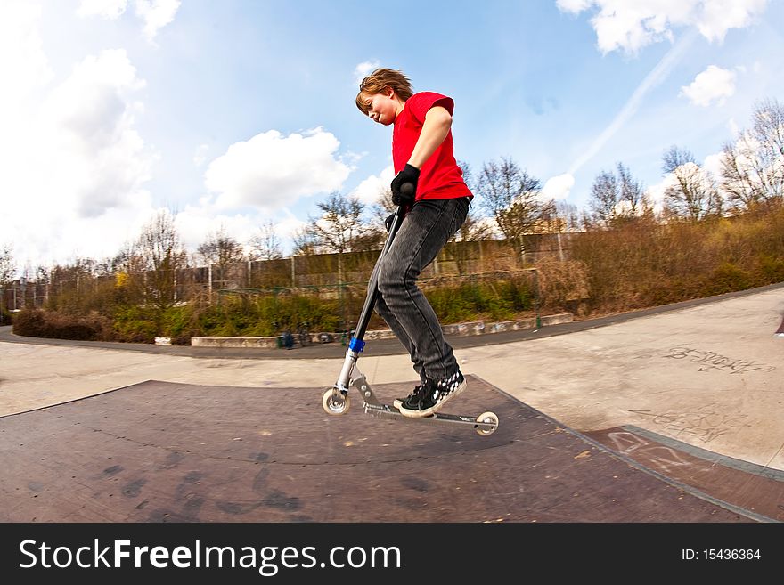 Boy jumping with a scooter over a funbox. Boy jumping with a scooter over a funbox