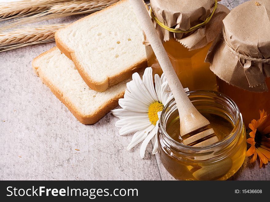 Tasty honey and bread on table