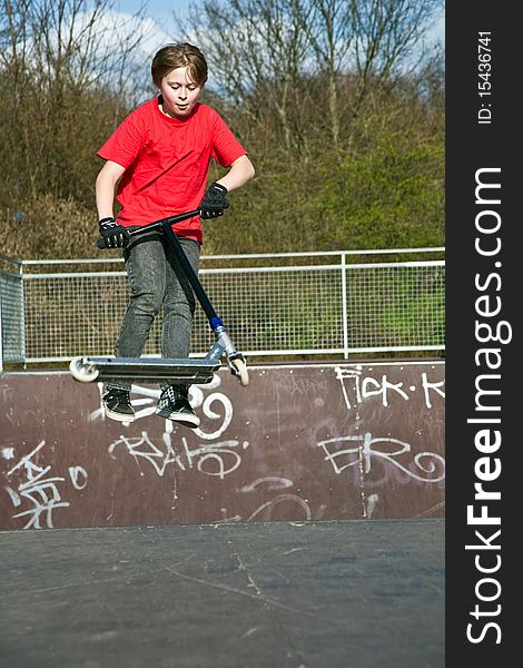 Boy jumping with a scooter over a funbox. Boy jumping with a scooter over a funbox