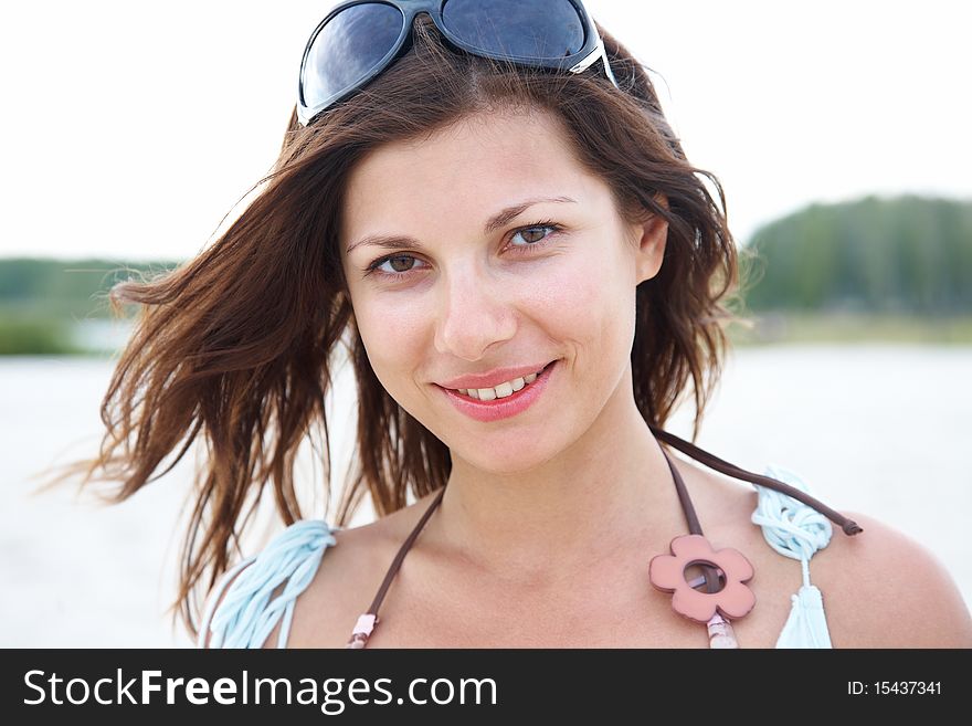 Portrait of young beautiful woman with brown hair on background of forest and lake. Portrait of young beautiful woman with brown hair on background of forest and lake