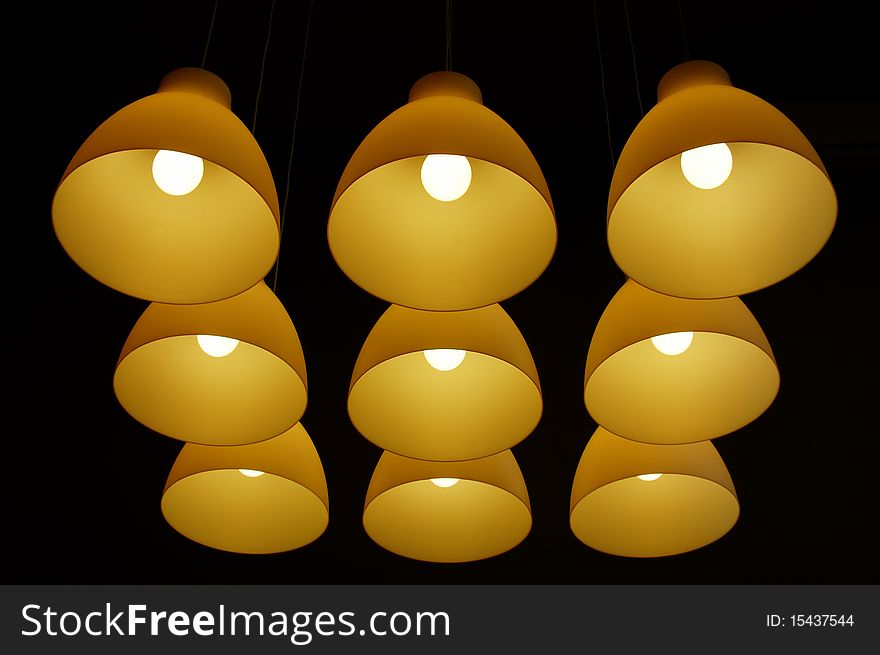 Set of ceiling lamps hanging on long cords in the darkness