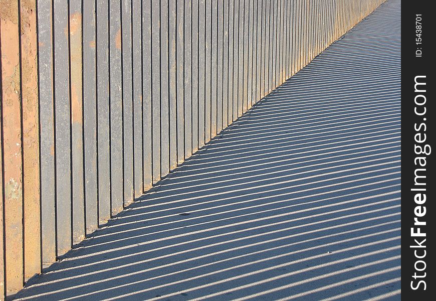 Image of barrier and striped shadow