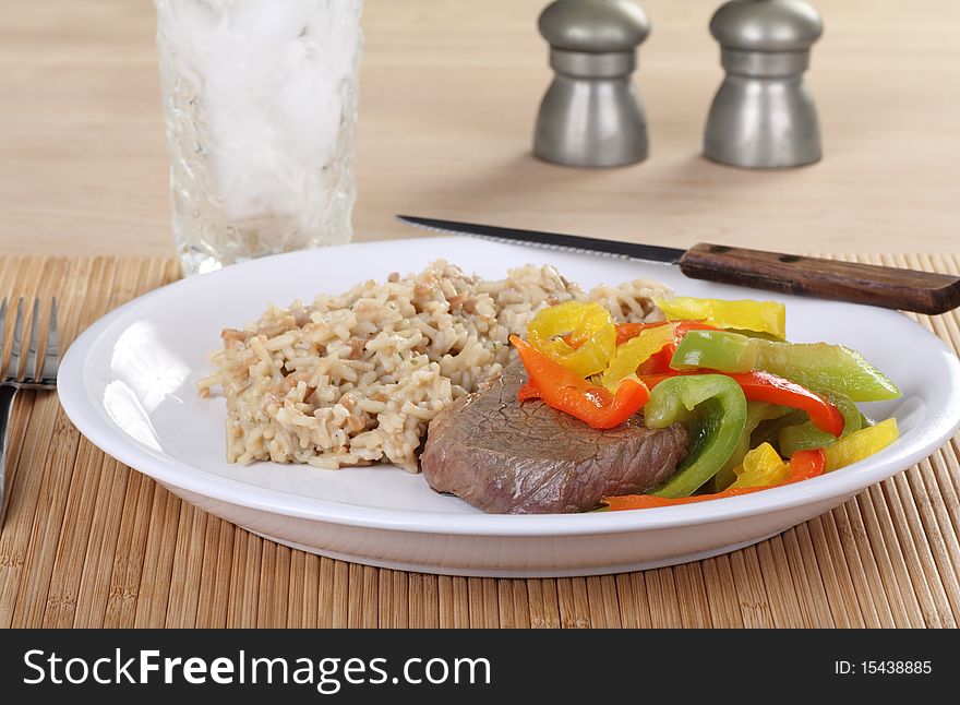 Sirloin steak meal covered with red and green bell peppers along with rice. Sirloin steak meal covered with red and green bell peppers along with rice