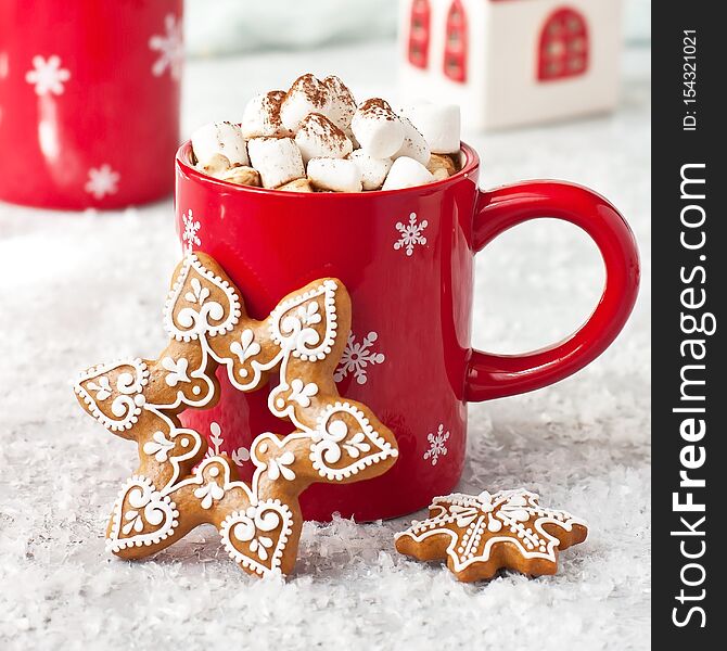 Red mug filled with hot chocolate, marshmallows and gingerbread cookies  on  light background