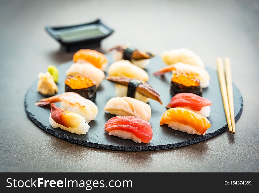 Nigiri sushi set with salmon tuna fish shrimp prawn eel shell and other sashimi on black slate - Japansese food style. Nigiri sushi set with salmon tuna fish shrimp prawn eel shell and other sashimi on black slate - Japansese food style