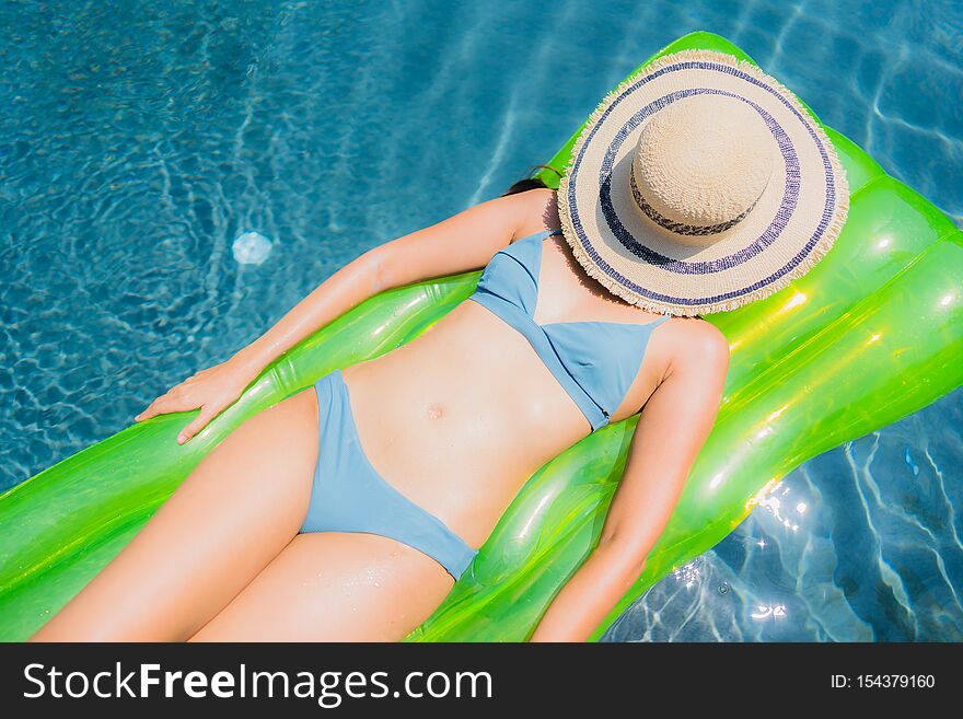 Portrait beautiful young asian woman smile happy relax and leisure in the swimming pool