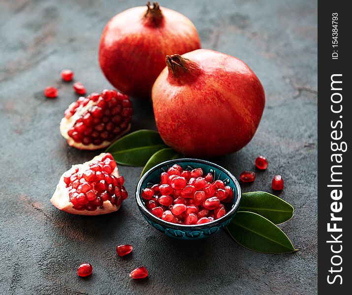 Ripe pomegranate fruits on  black concrete background