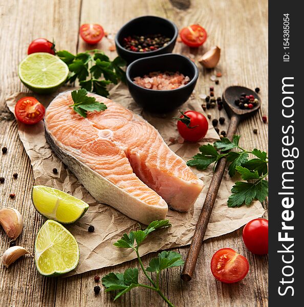 Raw salmon steaks and ingredients on a old wooden table