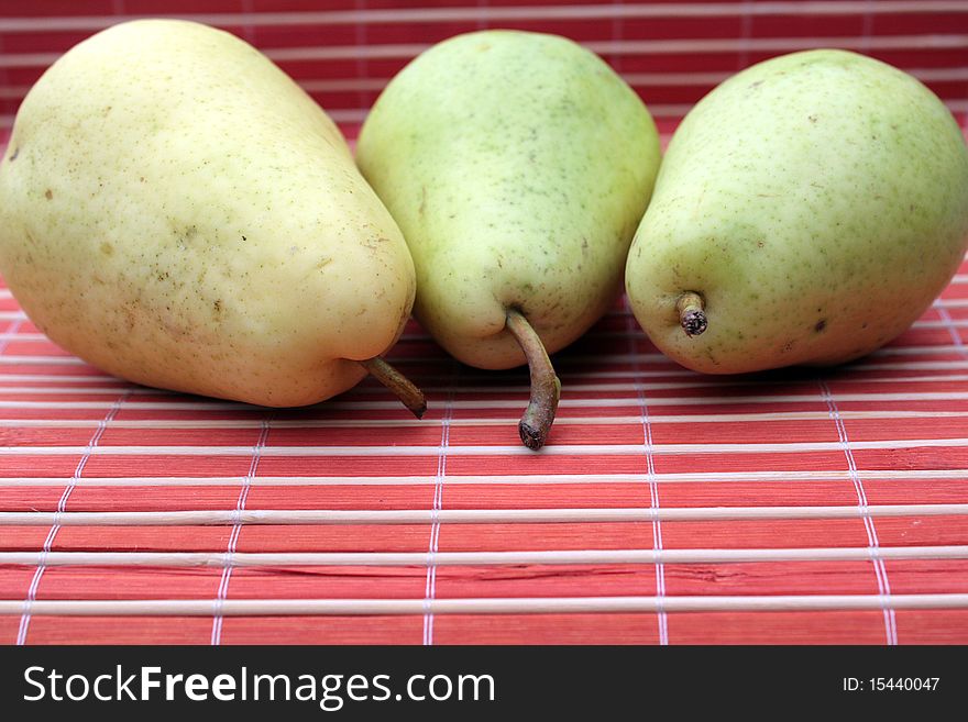 Three fresh pears in abstract red background