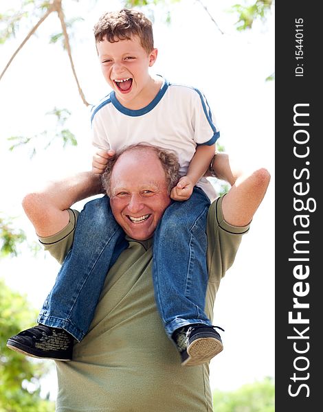 Grandpa enjoying himself as he makes his grandson sit on his shoulders