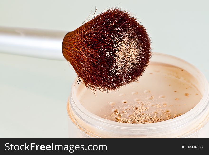 Brown cosmetic brush and container with face powder isolated on white. Brown cosmetic brush and container with face powder isolated on white