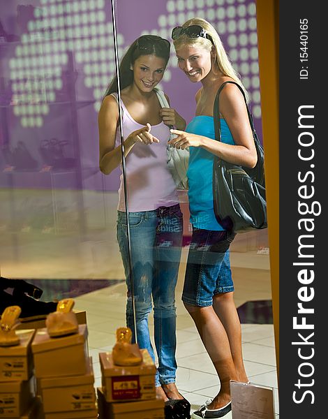 Young women looking through shop window